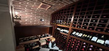 Photos by Andy James Heating LLC Beautiful custom wine cellar. Natural and timeless cherry wood racks and marble tile. Fully encapsulate with an air sp