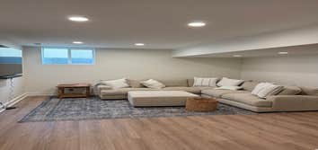 Open flex living area in this Elkhorn basement finish, designed for family movie nights and casual entertaining. Recessed LED lighting and neutral tone