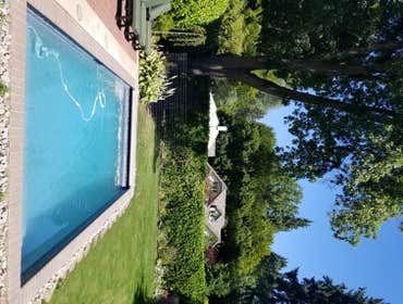 Tranquil Backyard Pool As you step into this remarkable sanctuary, a glistening swimming pool takes center stage, surrounded by paver slabs that gracef