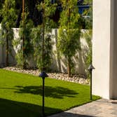 Front yard landscaping Enclosed yard with a retaining wall, and installed turf, pavers, and river rock garden border.