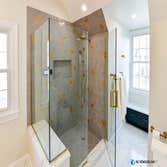 The Golden Master Bath We transformed this master bath into a bright and elegant space with golden fixtures and gorgeous blue cabinets. By opening up a