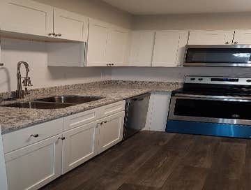 Photos by Combined Construction Services, Inc #1 Interior multi-family renovation including cabinets, countertops, flooring, paint, trim, and appliance