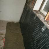 Foundation Waterproofing Inside Pictures show the process of installing a waterproofing membrane, drainage, sump pump pit and new concrete in the basem
