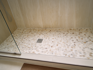Photos by Idrogo Construction Services LLC #2 “Complete bathroom remodel featuring a pebble mosaic shower base, large-format wall tiles with decorative