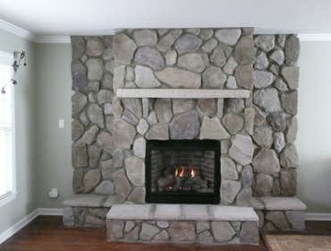 FIREPLACE Fire box was added to living room wall with external venting.
Frame was created to shape final look of fireplace.
Stone fascia, hearth and 