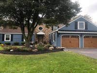 New siding, pent roof over garage doors and window.