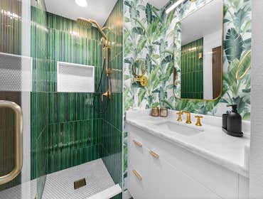 Katie | Master Bathroom This master bathroom remodel combines bold character with elegant finishes. Deep green vertical tile in the shower pairs with c