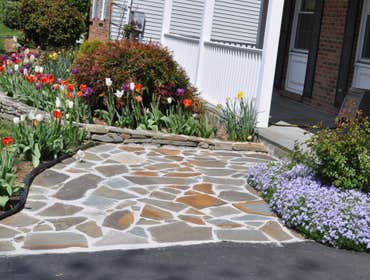 Stacked stone garden wall We used stacked stones and colorful landscaping to enhance the look of this yard in Silver Spring, MD