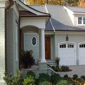 Carriage style doors First door (white with black hardware) is a stamped steel entry level door, second white painted custom door from Carriage House D