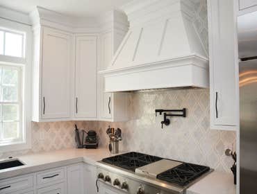 White hood vent and pot filler in this Frederick Kitchen remodel