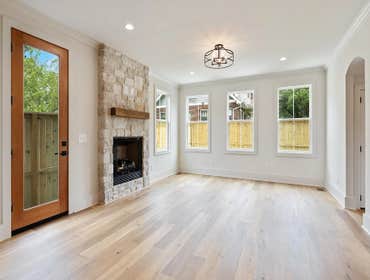 Open living and kitchen with stone fireplace and backyard access-CJMC Build at 2703 Bronte Ave, Nashville.