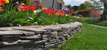 Stacked stone garden wall We used stacked stones and colorful landscaping to enhance the look of this yard in Silver Spring, MD