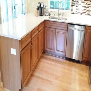 Kitchen remodel Removed breakfast nook wall and added flush steel beam in ceiling to open space. White quartz counters, cherry cabinets and glass tile 