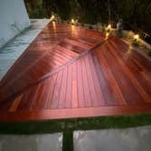Photos by Ajp Landscape Inc #2 Elegant Outdoor Installation with Concrete, Turf, and Ipe Wood Decking
This custom outdoor project features a sleek gri