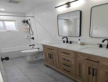 Photos by M&c Global Construction LLC #10 This Odenton, MD, bathroom remodel transformed the space with a dual vanity, new bathtub with tiled walls, an