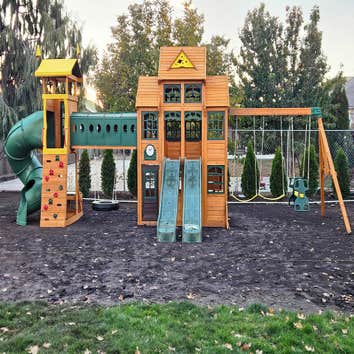 Photos by Timber Mount LLC #2 Assembled and installed a large custom wooden playhouse with dual slides, climbing wall, swing set, and connecting tunnel